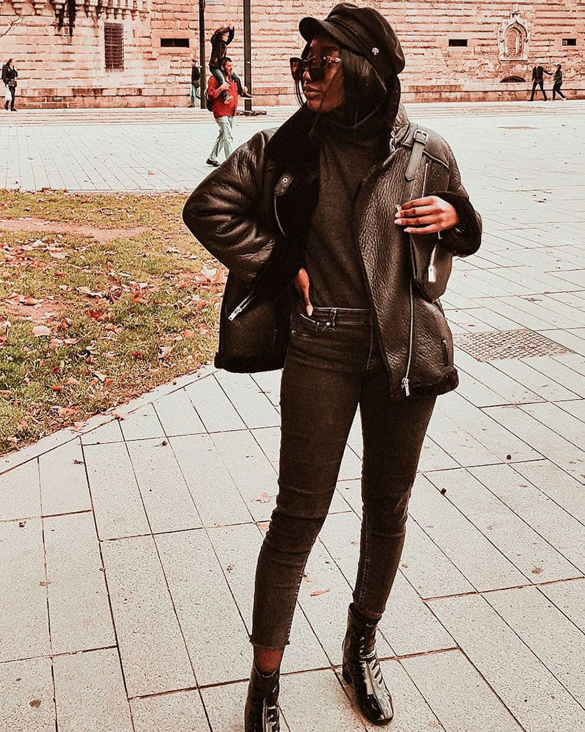 Woman wearing a black leather jacket paired with skinny jeans and ankle boots for a chic streetwear look.