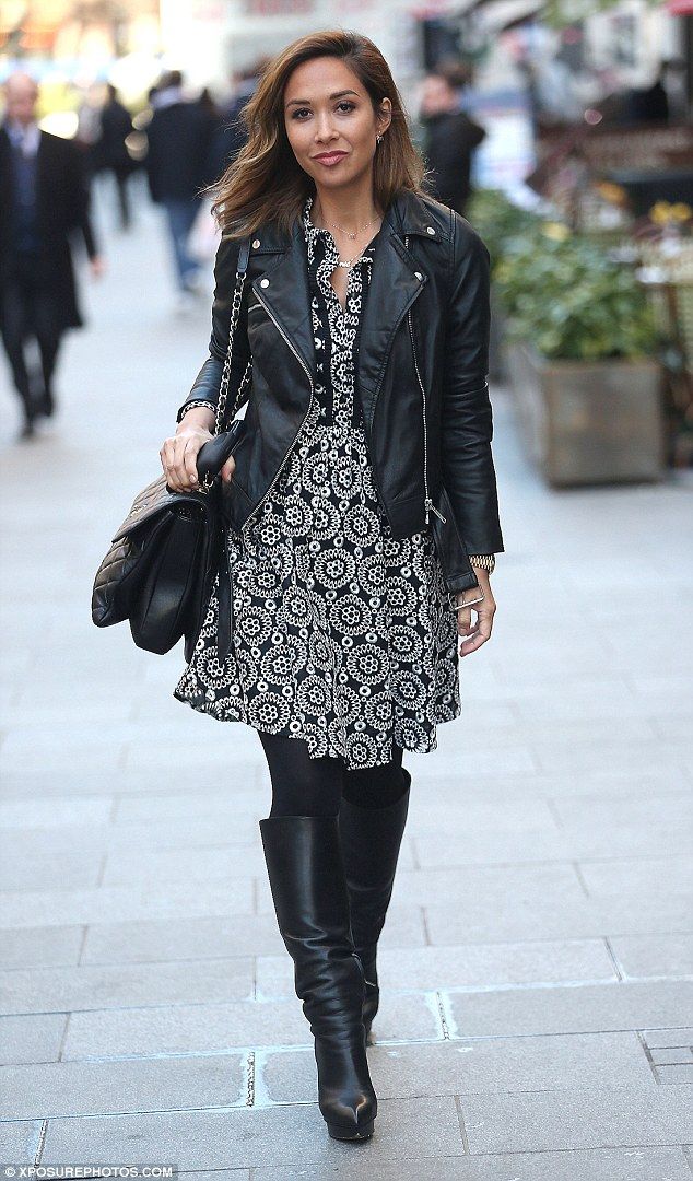 Woman wearing a floral dress paired with a black leather jacket and ankle boots.